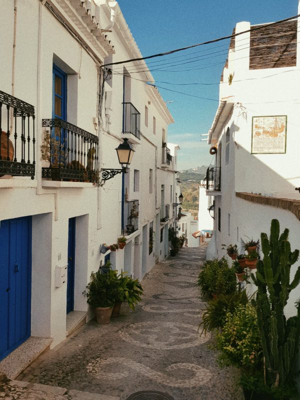 Little walk path in Andalusia between white buildings on sunny day