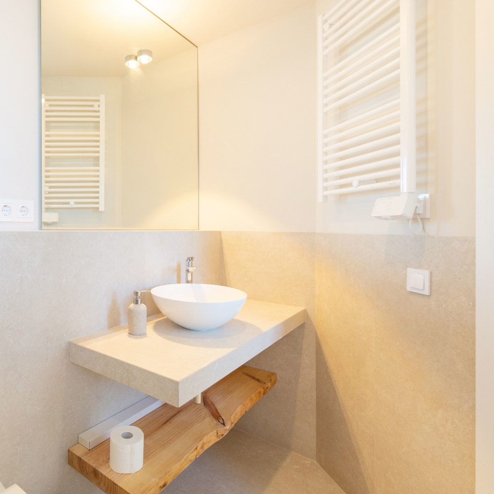 Renovated bathroom with warm light, white sink and mirror