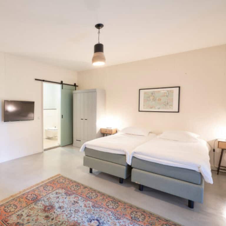 White bedroom with doublebed and en-suite bathroom