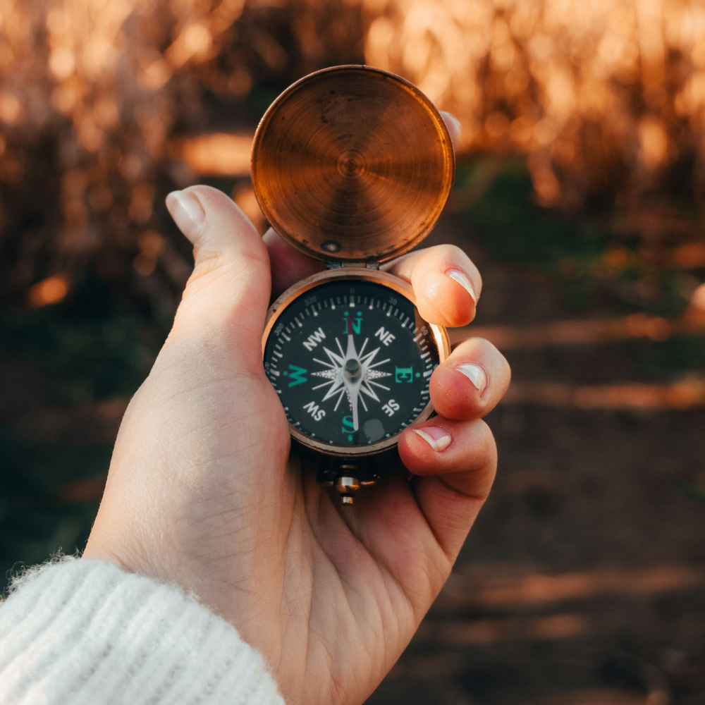 Woman holding a compass in her hand in nature