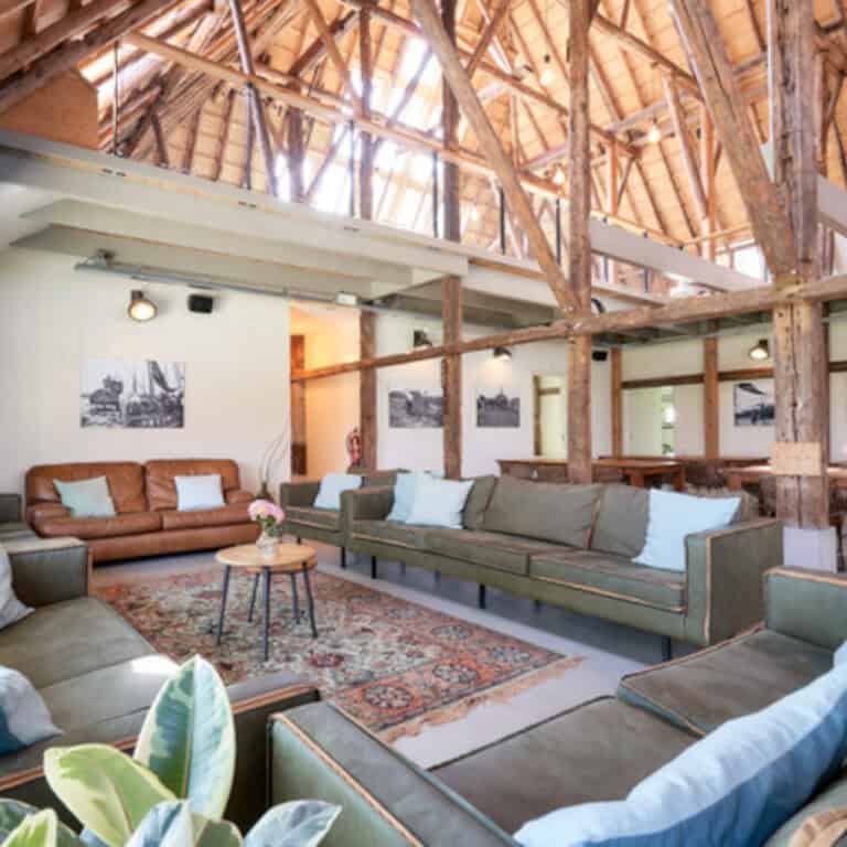 Huge living room with three green couches and one brown couch