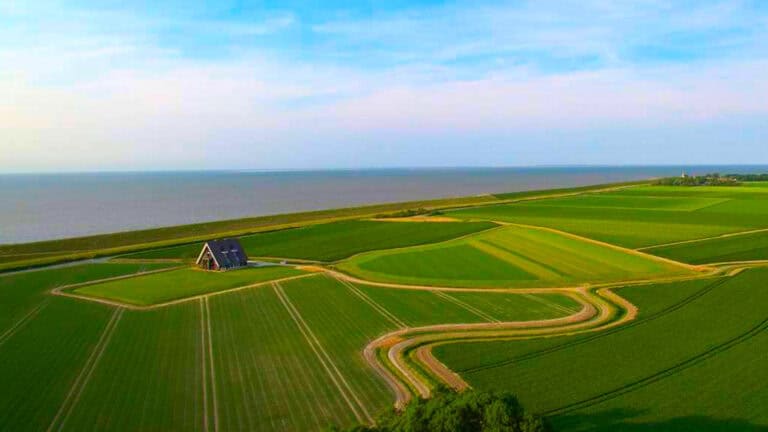 Dutch house in gras field drone picture, blue sky with some clouds