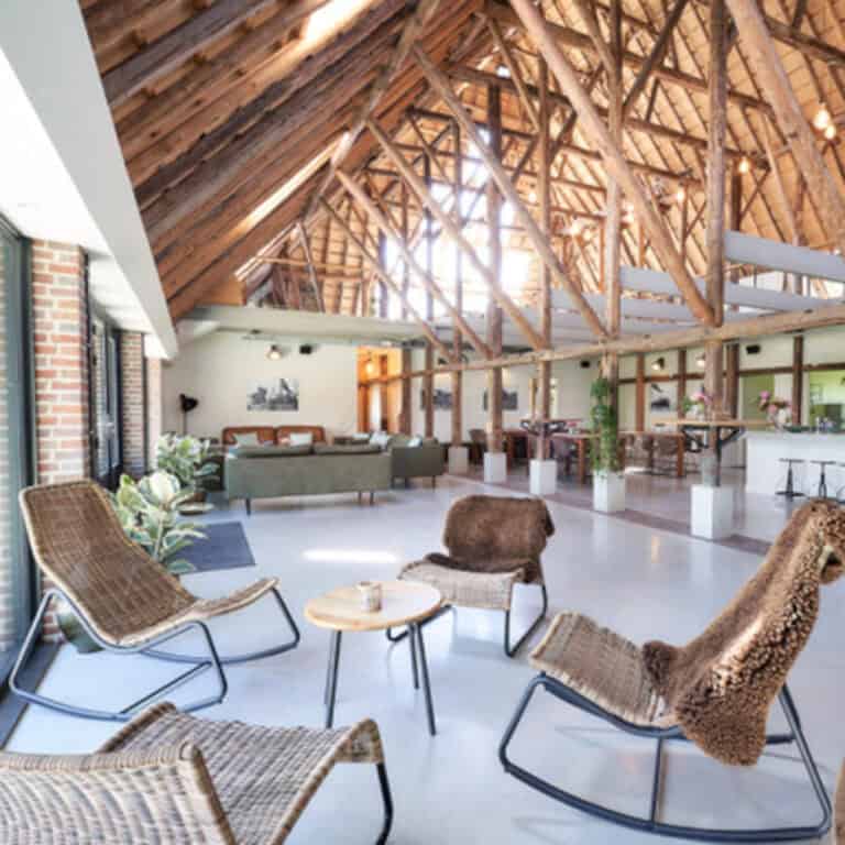 Sitting corner with four rocking chairs, in the background a huge room with wood elements