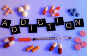 The word addiction and pills and a needle around it