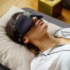 Woman with black Rejuvyn blindfold laying on mattress