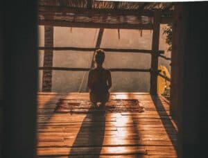 Meditating woman in a wooden room