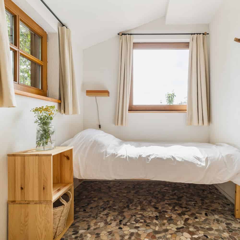 One of the double rooms. It is a bright room with white walls. All the furniture, the door and the bedside lamp are made of solid wood. The room streets a serene peace.