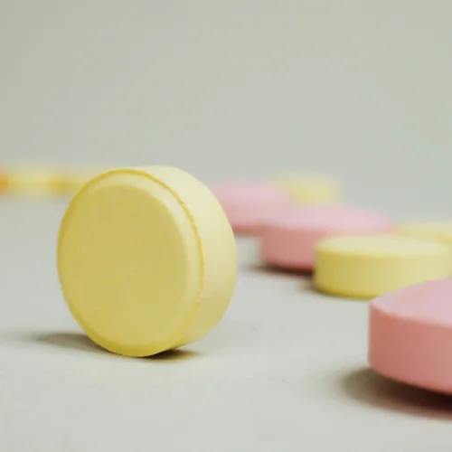 LSD pill illustration, yellow and red pills on table